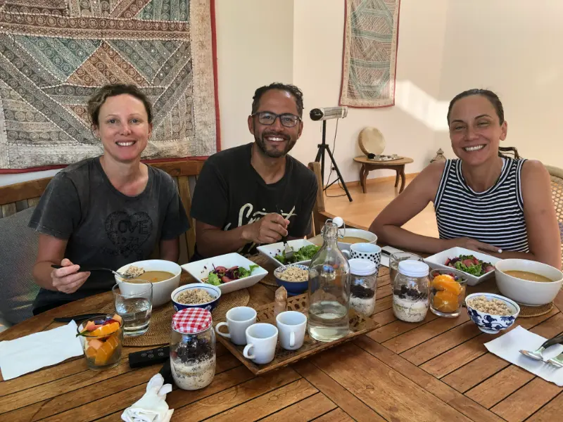 Guests smiling over a shared plant-based lunch