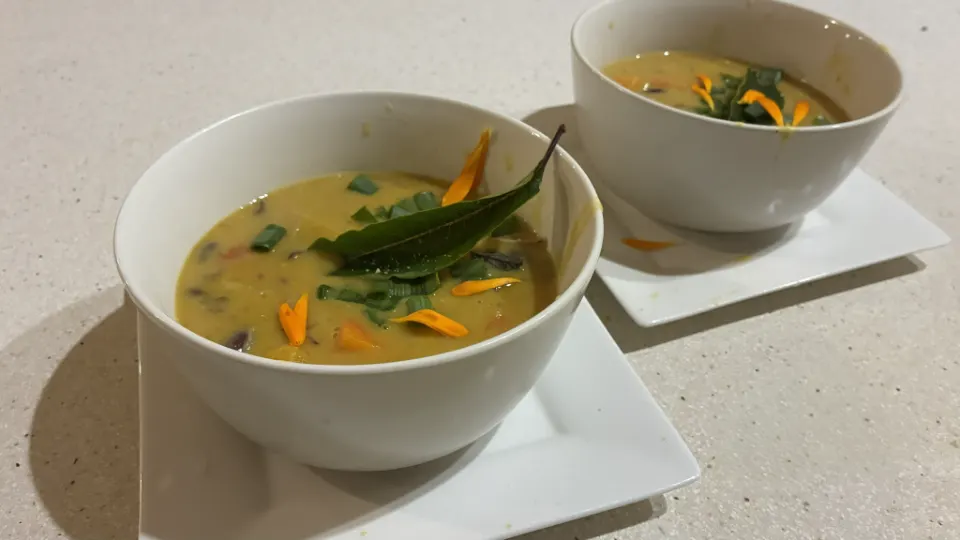 Bowls of vegetable soup garnished with calendula petals